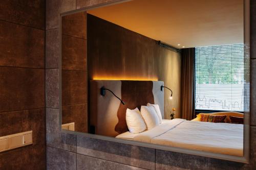 a mirror above a bed in a bedroom at City Center Lodge Utrecht in Utrecht
