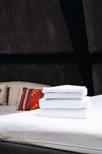 a stack of towels stacked on top of a bed at City Center Lodge Utrecht in Utrecht