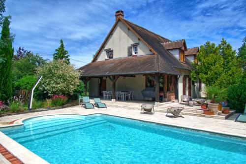 une maison avec une piscine devant une maison dans l'établissement La picoiserie, à Cellettes