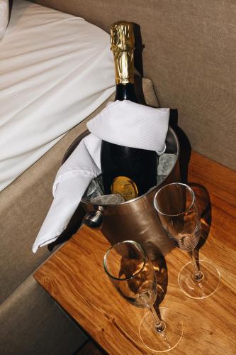 a bottle of wine in a bucket on a table with two glasses at City Center Lodge Utrecht in Utrecht