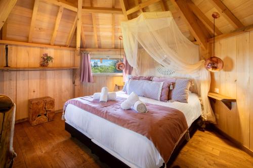 Un dormitorio con una cama grande en una habitación con paredes de madera. en Domaine de Campagnac - Spa & Sauna, en Carsac-Aillac