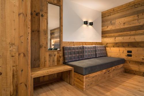 a bench in a room with wooden walls at Albergo alla Posta in Madonna di Campiglio