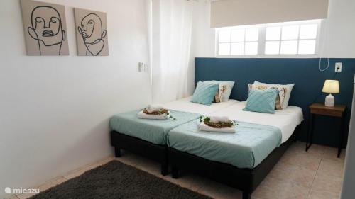 two beds in a room with blue and white at 4BlessingsCuracao2 in Willemstad