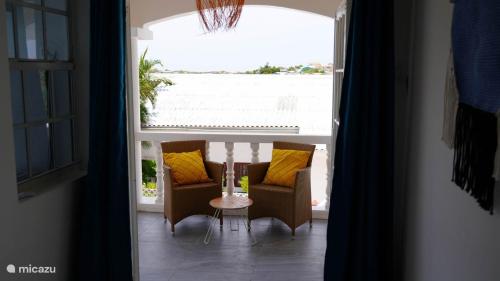 a room with two chairs and a table and a window at 4BlessingsCuracao2 in Willemstad