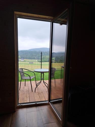 a room with a balcony with a table and chairs at Domki w Bieszczadach Nowa Zelandia in Berezka