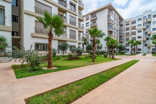 a walkway with palm trees in front of a building at AeroSerenity in Nouaceur