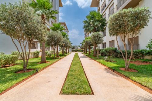 a walkway between buildings with trees and grass at AeroSerenity in Nouaceur