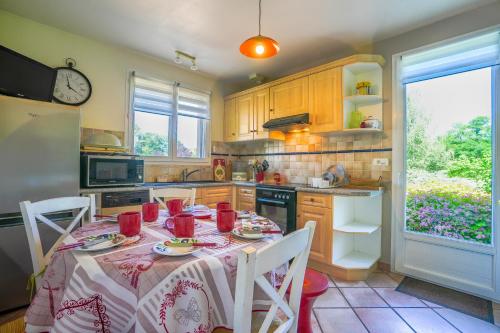 - une cuisine avec une table et des tasses rouges dans l'établissement Lou Poutou du Levant, à Gramat