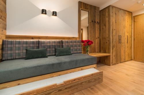 a couch in a room with wooden walls at Albergo alla Posta in Madonna di Campiglio