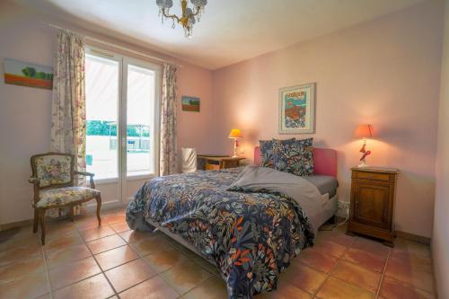 une chambre avec un lit, une chaise et une fenêtre dans l'établissement Lou Poutou du Levant, à Gramat