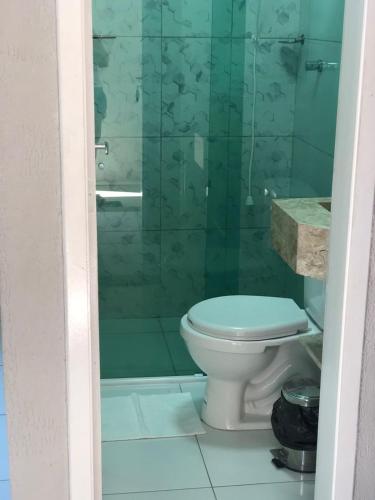 a bathroom with a toilet and a glass shower at Terraço Hotel Lagoinha in Lagoinha