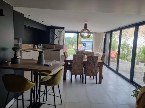 une cuisine et une salle à manger avec une table et des chaises dans l'établissement gîte de la Rance, à Saint-Samson-sur-Rance