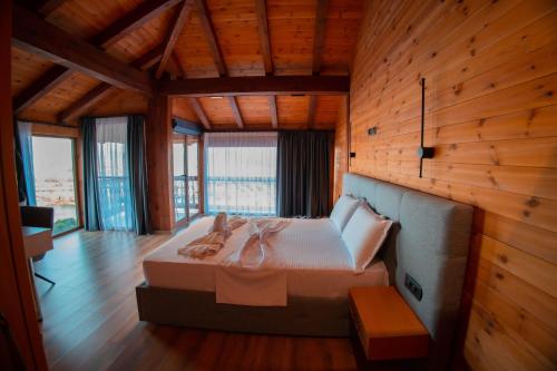 a bedroom with a bed in a room with wooden walls at Hotel Shpija e Gjyshit in Shkodër