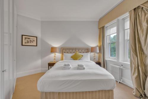 a bedroom with a large white bed and a window at Knightsbridge - Hans Place Apartments in London