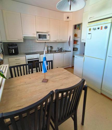 Una cocina con una mesa de madera con una bandera azul encima. en Cozy dobbel with sauna & balcon, en Tampere