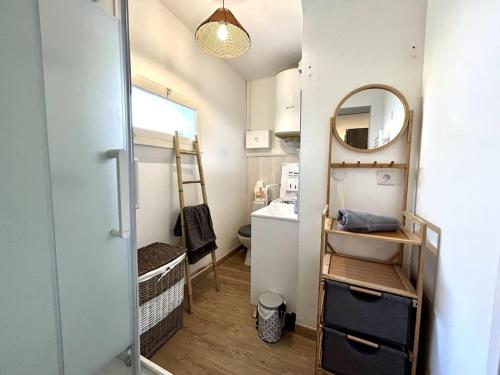 une petite salle de bain avec un lavabo et un miroir dans l'établissement Côté Cour - Appartement en plein centre-ville & proche des thermes, à Rochefort