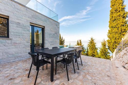 a black table and chairs on a patio at Villa Serenity Luxury Lakeside Manor in Široka
