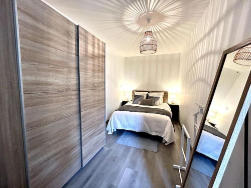 - une chambre avec un lit et un grand mur dans l'établissement Côté Cour - Appartement en plein centre-ville & proche des thermes, à Rochefort