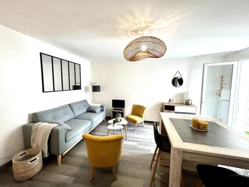 un salon avec un canapé et une table dans l'établissement Côté Cour - Appartement en plein centre-ville & proche des thermes, à Rochefort