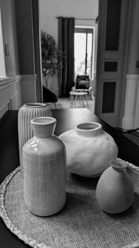 trois vases assis sur une table dans un salon dans l'établissement Château au milieu du vignoble avec piscine à 10 mn des plages, à Cabestany