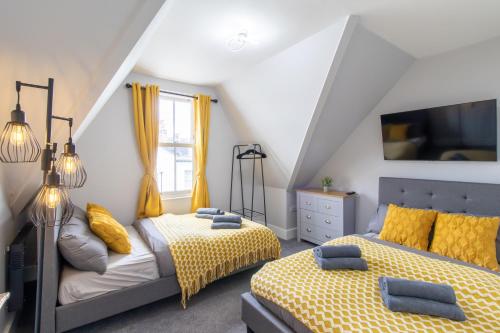 a bedroom with two beds with yellow sheets at Open Mind Property - Cosy Apartment with 2 Beds in Portsmouth