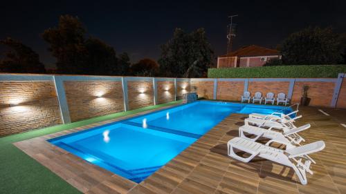 a swimming pool with lounge chairs next to it at night at Hotel Hohenau in Hohenau