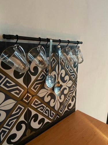 a group of wine glasses hanging from a wall at Apartament Gold 4 in Złotoryja