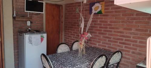 a dining room table with chairs and a brick wall at Apartamentos Agosto in Nueva Galia