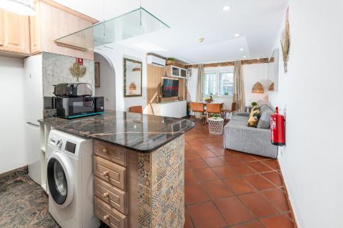 a kitchen with a washer and dryer and a living room at Calas Beach Corralejo in Corralejo