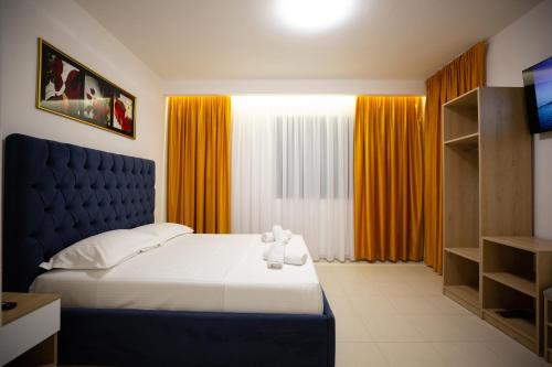 a bed with two teddy bears on it in a bedroom at Frekel Hotel in Tirana