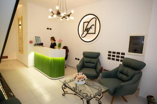 a woman standing at a counter in a waiting room at Frekel Hotel in Tirana