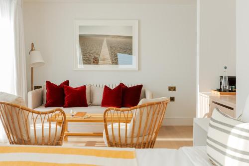 a living room with a couch with red pillows at Moonfleet Manor Hotel in Weymouth