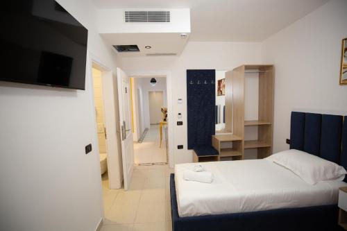 a bedroom with a white bed and a bathroom at Frekel Hotel in Tirana