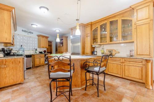 a kitchen with wooden cabinets and bar stools at Idilio Escape in Ocho Rios