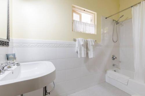 a white bathroom with a sink and a shower at Idilio Escape in Ocho Rios