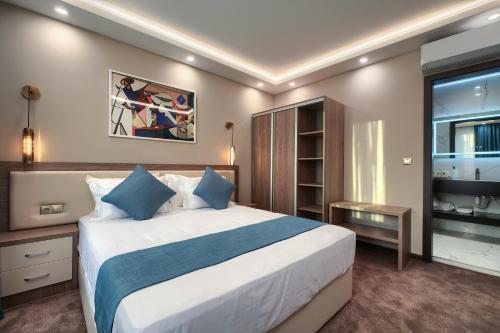 a bedroom with a large bed and a large window at Aurora Sofia in Sofia