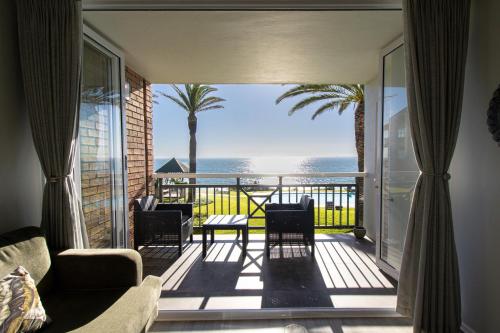 a living room with a balcony with a view of the ocean at Brookes Hill Suites Luxury Apartment 124 in Port Elizabeth