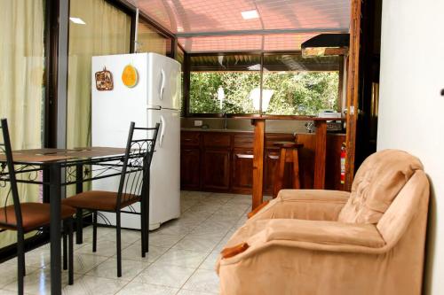 a kitchen with a couch and a table and a refrigerator at Centro Ecológico La Ribera-CABINA 5 in San Rafael