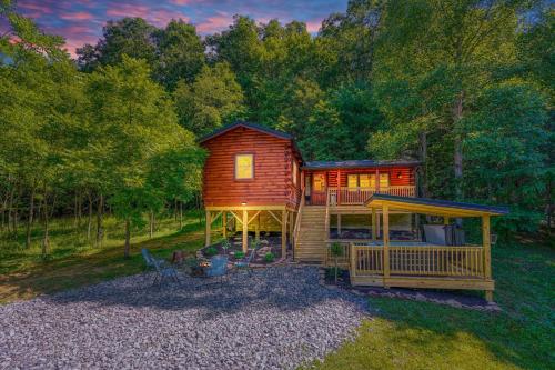 a cabin in the woods with a porch and a deck at Moonlight Waters by Pond in South Bloomingville