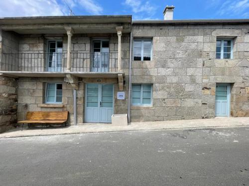 a stone building with a bench in front of it at Casa do queixeiro in Castroverde