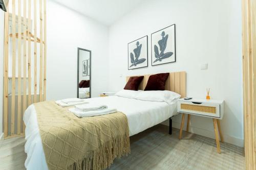 una camera da letto bianca con un letto grande e un tavolo di La palmera apartment a Santander