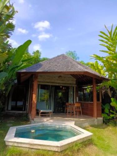 a house with a swimming pool in front of it at Sunrise Paradise Bali in Karangasem