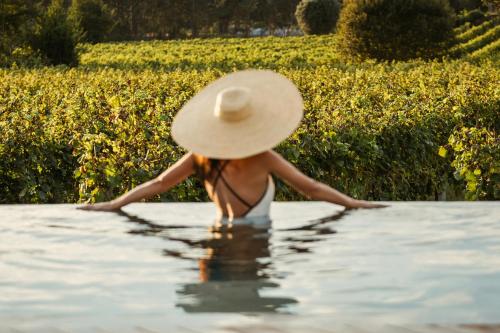 a woman in a straw hat in the water at Vinha by NHôme in Ponte de Lima