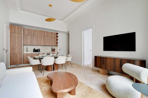 un salon avec une table et une télévision dans l'établissement Luxury Apartment - 2BR-4P - GeorgeV-Champs Elysees, à Paris