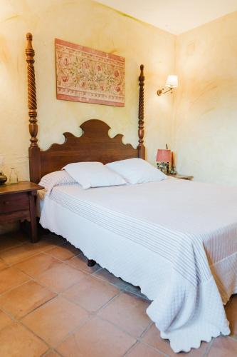 a bedroom with a large bed with white sheets at Casa rural con jacuzzi en centro histórico de Pals in Pals