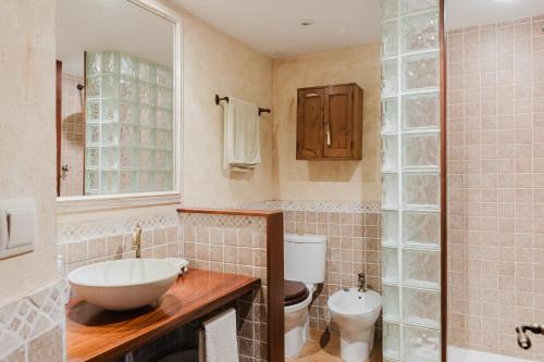 a bathroom with a sink and a toilet at Casa rural con jacuzzi en centro histórico de Pals in Pals