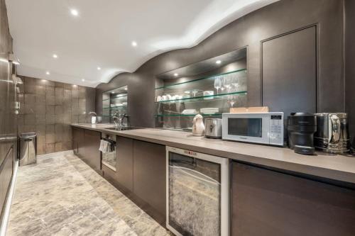a kitchen with a counter with a microwave at Knightsbridge - Hans Place Apartments in London