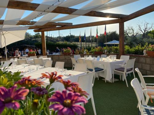 a restaurant with white tables and white chairs and flowers at Casale Antonietta in Sorrento