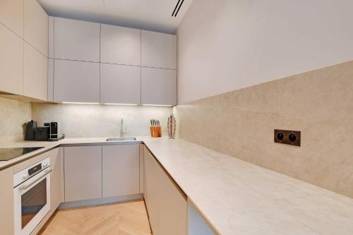une cuisine avec des armoires blanches et un comptoir dans l'établissement Luxury apartment with AC - GeorgeV-Champs Elysees, à Paris
