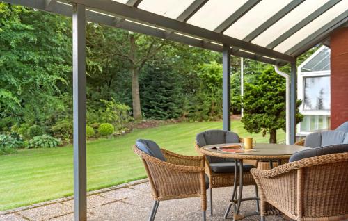 a patio with a table and chairs under a pergola at 4 Bedroom Gorgeous Home In Varde in Varde